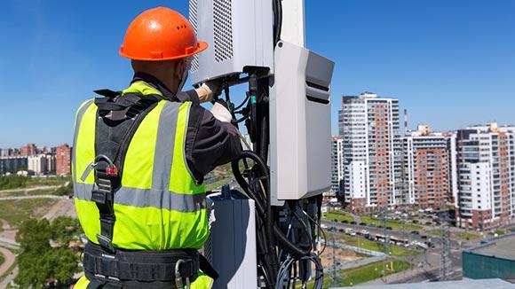 Telecommunications engineer working above a cityscape.